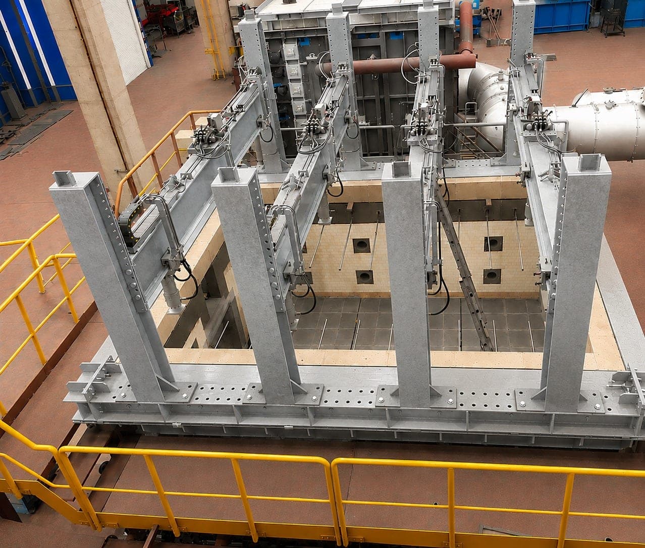 Horizontal furnace seen from above, with the loading frame and hydraulic cylinders positioned over the test opening