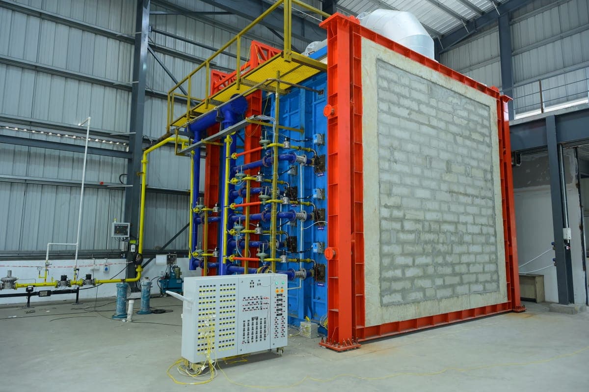 Vertical fire resistance test furnace with a masonry specimen wall mounted in the specimen frame